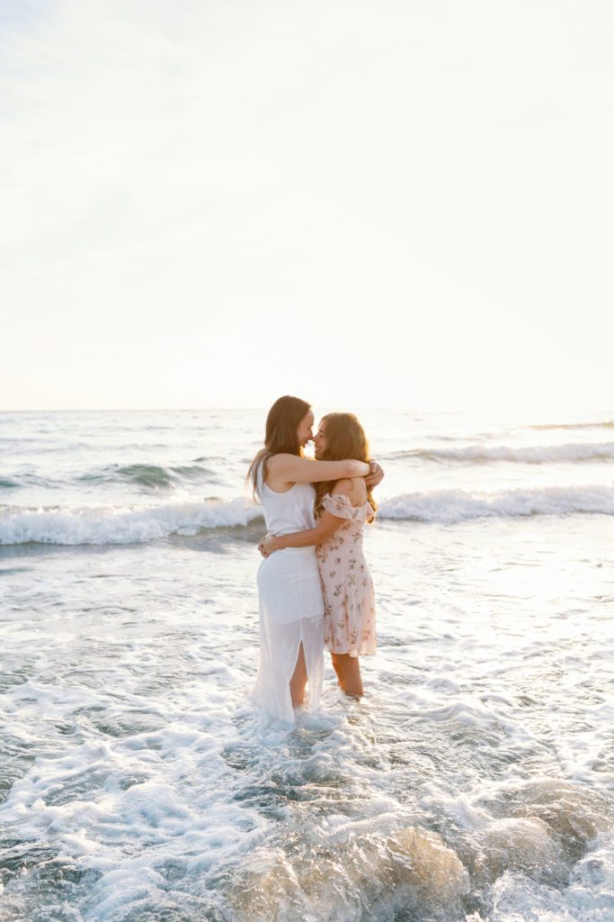 girls hugging in the waves of the beach